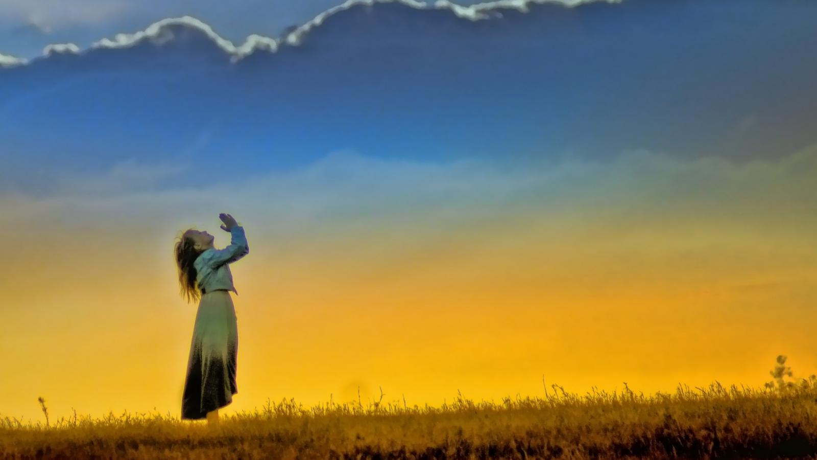 Woman praying in the Sunset